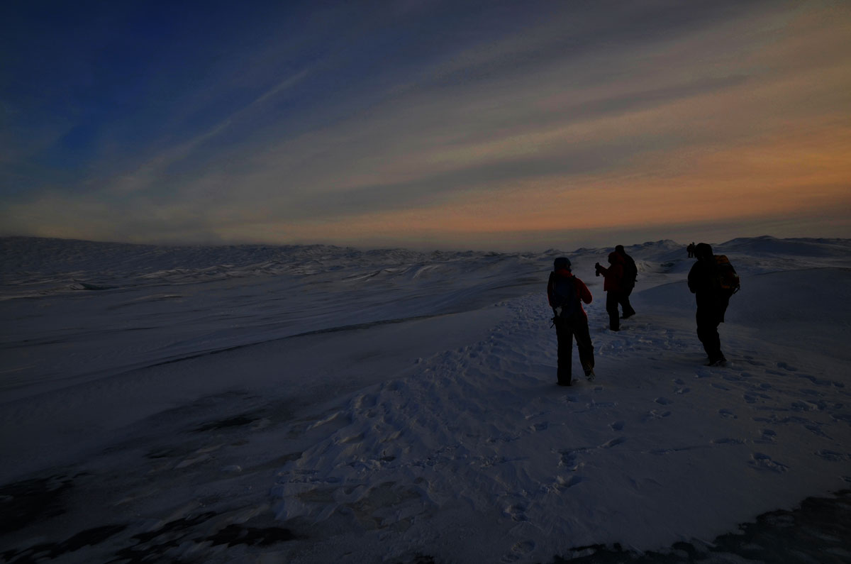 Des enfants marchent dans l'obscurité, c'est l'hiver. 