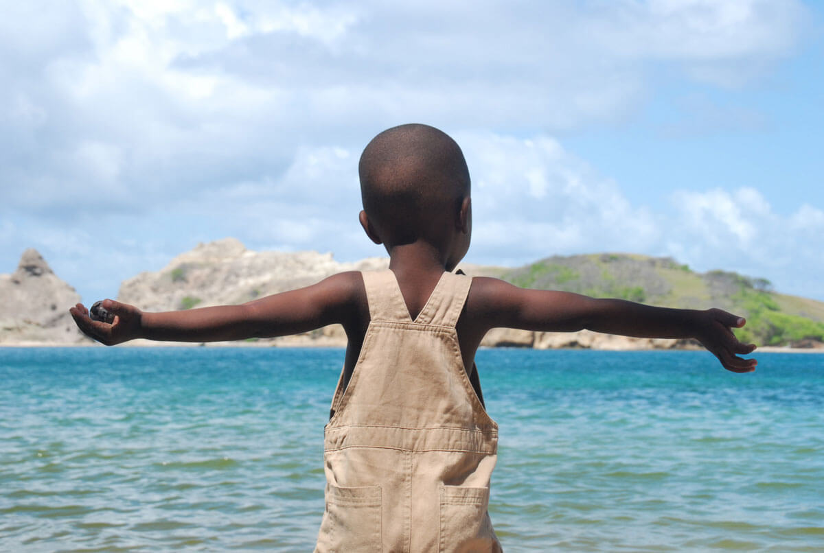 Un enfant haïtien qui marche dans l'eau.