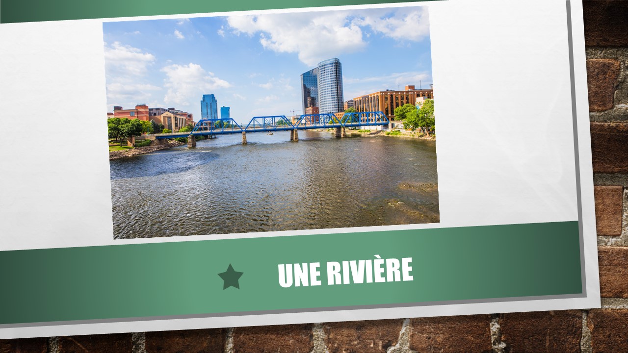 Photo montrant une rivière. On voit aussi un pont et une ville. 