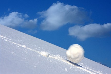 Une boule de neige dévalant une pente. 